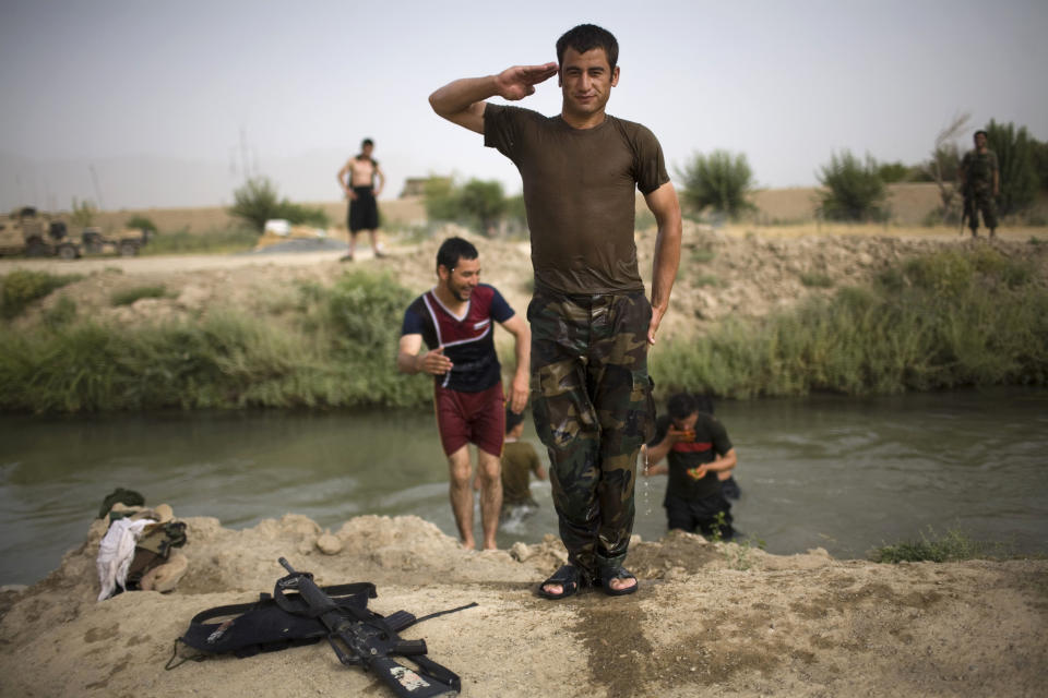 <p>An Afghan army soldier poses after swimming in a canal near the joint Afghan-U.S. base COP Nolen, in the volatile Arghandab Valley, Kandahar, Afghanistan, July 22, 2010. (Photo: Rodrigo Abd/AP) </p>