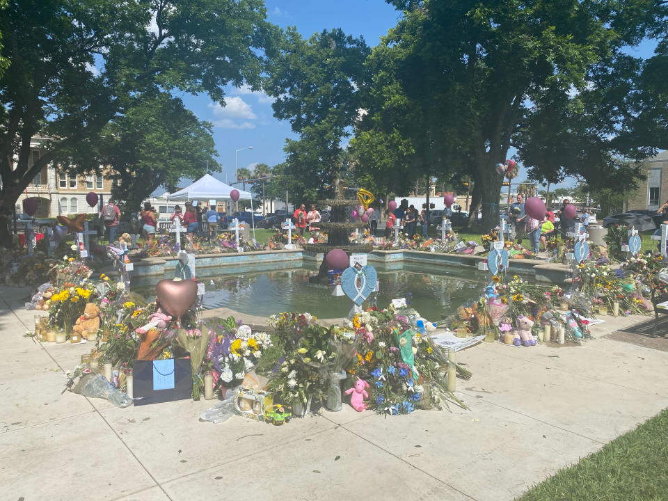 No one knows who put up the white crosses in the center of town, but the memorial around them keeps growing.