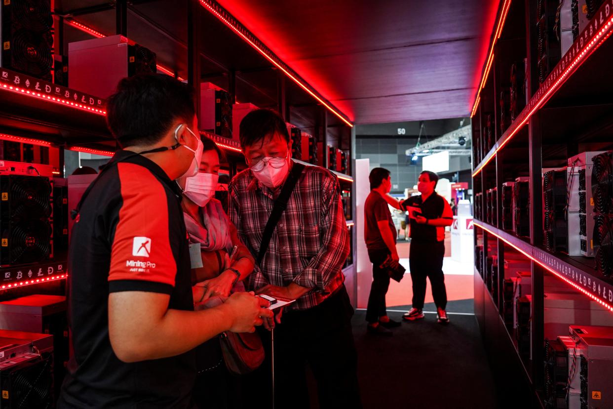 Visitors inspect crypto mining equipment at the Thailand Crypto Expo in Bangkok, Thailand, 14 May 2022.