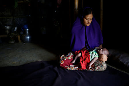 Rajuma Begum, 28, poses for a photograph with her one-month-old son Raihan inside their shelter in Kutupalang unregistered refugee camp in Cox’s Bazar, Bangladesh, February 12, 2017. REUTERS/Mohammad Ponir Hossain