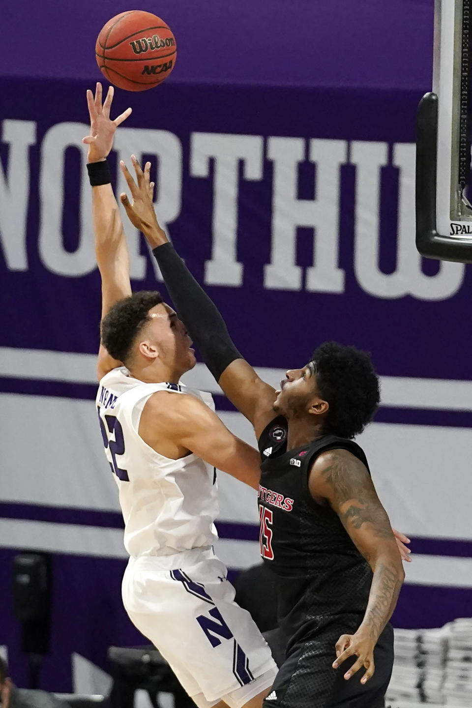 Northwestern forward Pete Nance, left, shoots over Rutgers center Myles Johnson, right, during the first half of an NCAA college basketball game in Evanston, Ill., Sunday, Jan. 31, 2021. (AP Photo/Nam Y. Huh)