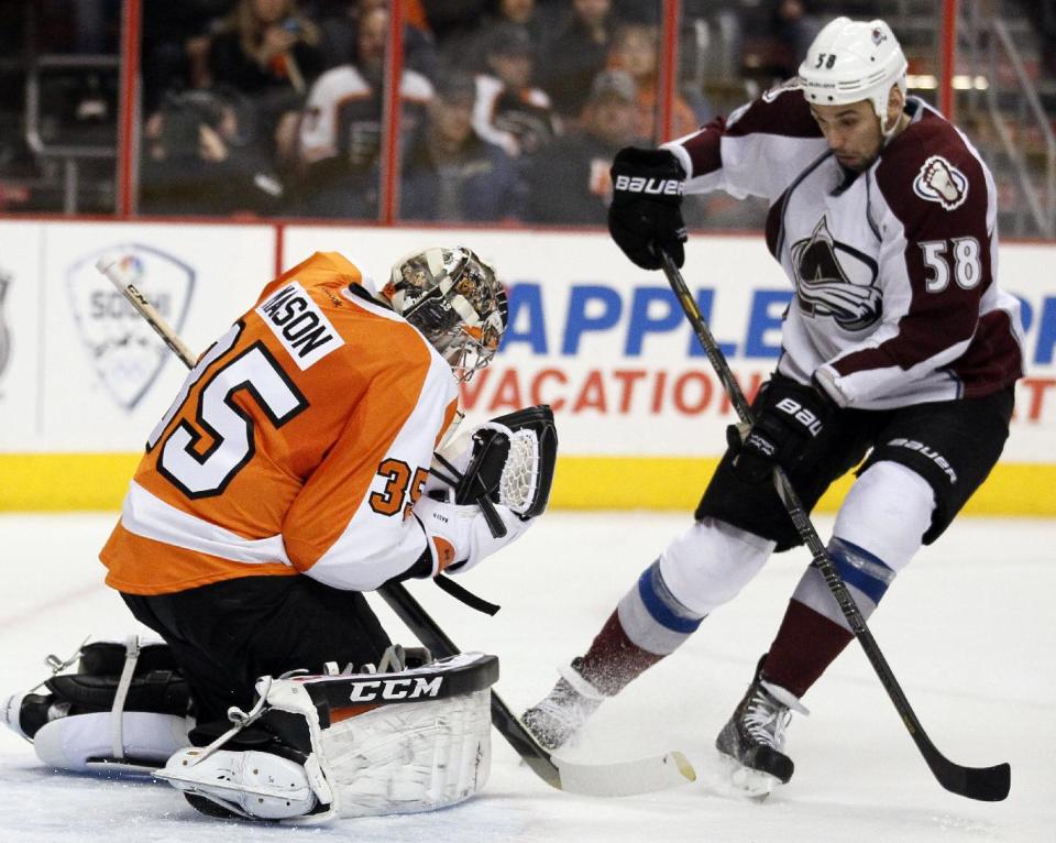 Philadelphia Flyers' Steve Mason, left, gloves the puck as Colorado Avalanche' Patrick Bordeleau, right, moves in during the first period of an NHL hockey game, Thursday, Feb. 6, 2014, in Philadelphia. (AP Photo/Tom Mihalek)