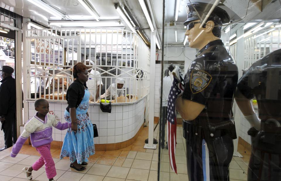 Customers walk past a statue depicting a New York Police Department (NYPD) officer at the entrance of a fast-food restaurant, ahead of a scheduled state visit by U.S. President Barack Obama, in Kenya's capital Nairobi July 23, 2015. Obama will land in Kenya on Friday with a mission to strengthen U.S. security and economic ties, but his personal connection to his father's birthplace will dominate a trip that Kenyans view as a native son returning home. (REUTERS/Thomas Mukoya)