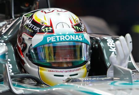 Mercedes Formula One driver Lewis Hamilton of Britain puts on his gloves during the third practice session of the Singapore F1 Grand Prix at the Marina Bay street circuit in Singapore September 20, 2014. REUTERS/Edgar Su