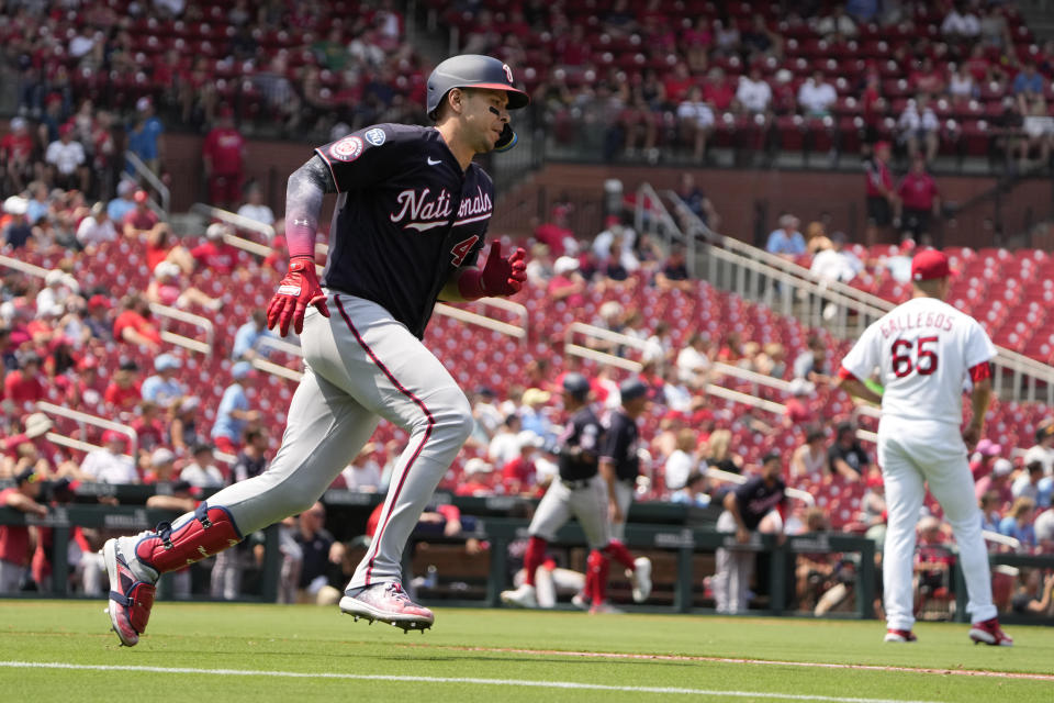 Washington Nationals' Joey Meneses, left, rounds first on his way to an RBI double off St. Louis Cardinals relief pitcher Giovanny Gallegos (65) during the eighth inning in the first game of a baseball doubleheader Saturday, July 15, 2023, in St. Louis. The contest was the resumption of a game started on Friday, but was suspended due to rain. (AP Photo/Jeff Roberson)