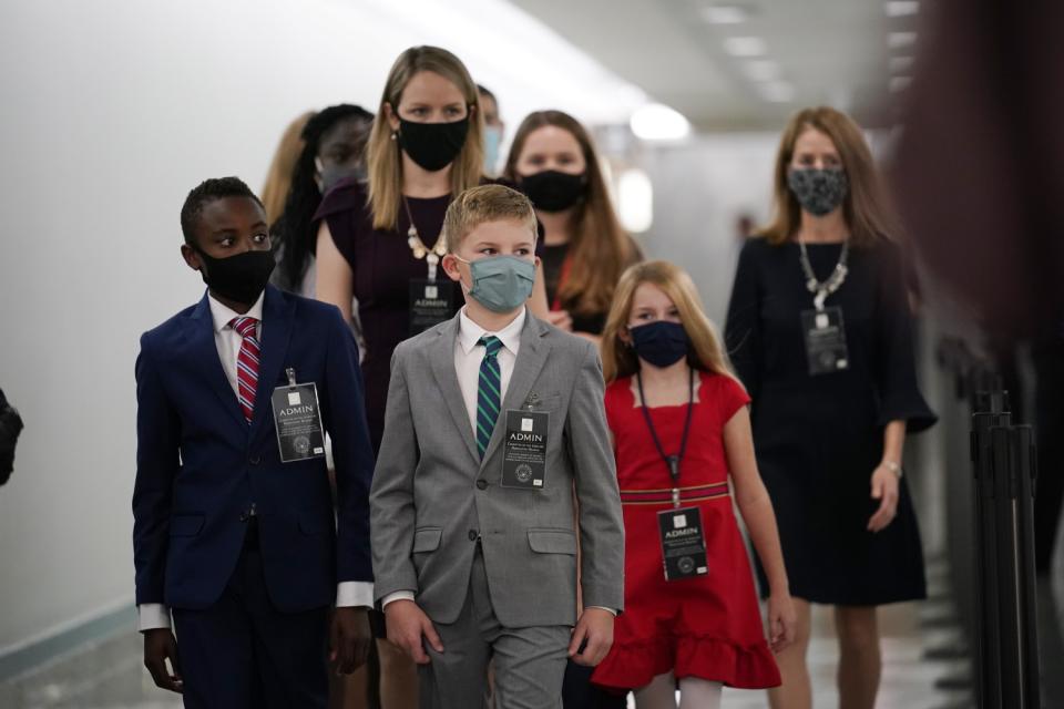 Wearing suits and dresses, children of Supreme Court nominee Amy Coney Barrett arrive on Capitol Hill.