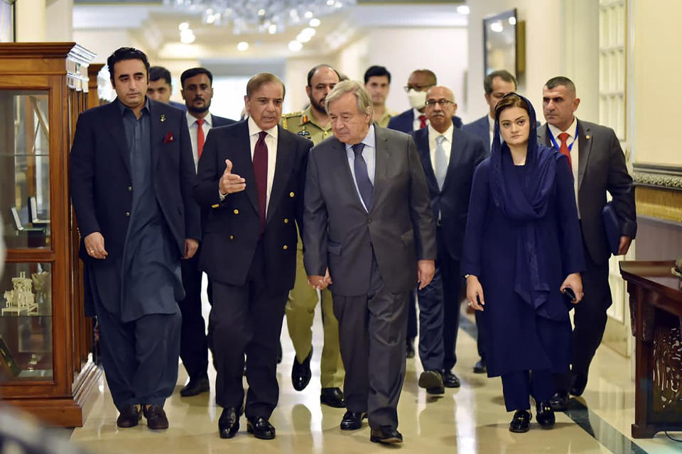 In this handout photo released by Pakistan Prime Minister Office, U.N. Secretary-General Antonio Guterres, center, walk with Pakistan Prime Minister Shahbaz Sharif as they chat with each others at the Prime Ministry office in Islamabad, Pakistan, Friday, Sept. 9, 2022. Guterres appealed to the world to help Pakistan after arriving in the country Friday to see climate-induced devastation from months of deadly record floods that have left half a million people living in tents under the open sky. (Pakistan Prime Minister Office via AP)