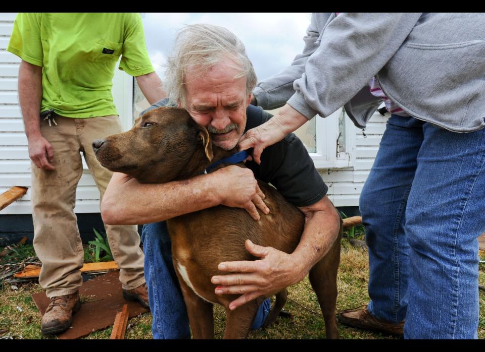 Greg Cook hugs his dog Coco after finding her inside his destroyed home in Alabama following the tornado in March 2012. 