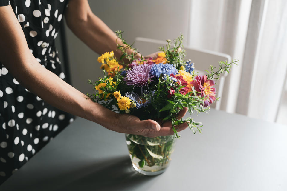 a person holding a vase of flowers