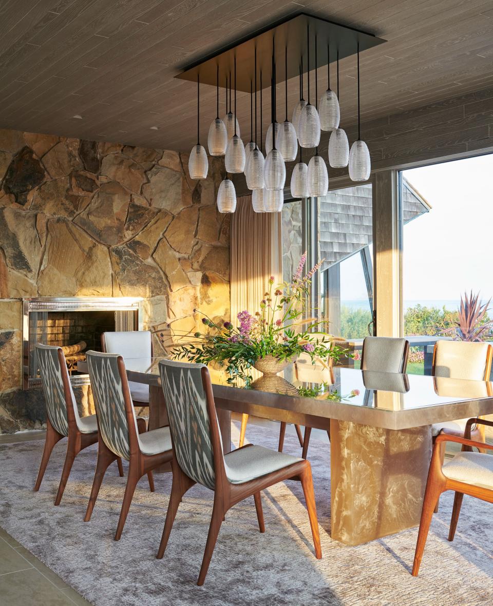 The colors of the sand and seashells on the beach, as well as the stones on the wall, informed the dining room’s decor. Moon designed this cast-resin table with an inset glass top. “I wanted a table that would feel architectural, but not heavy,” he says. “I settled on this amber resin with a smoky effect. It reminded me of the waves washing up on the beach.” The Vladimir Kagan “sculpted sling” chairs were upholstered in an ivory acrylic yarn from Link and a handwoven ikat from Bermingham & Co.