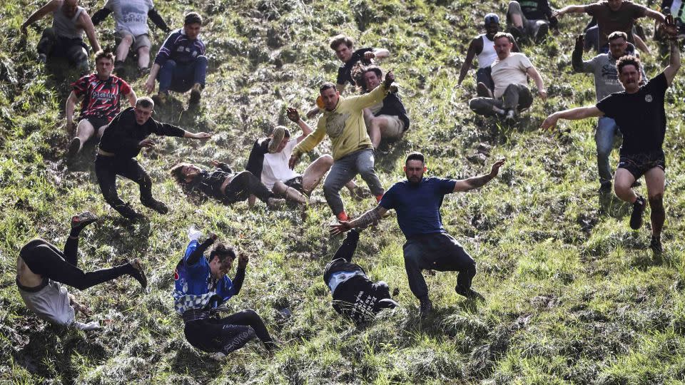 Chaotic scenes as competitors come tumbling down the hill during the annual Cooper's Hill cheese-rolling competition. - Henry Nicholls/AFP/Getty Images