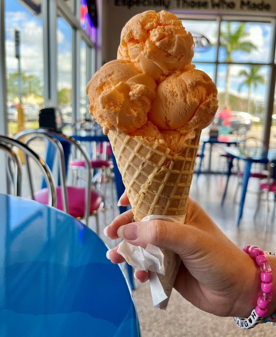 A small waffle cone filled with orange creamsicle ice cream from Love Boat's new store in Cape Coral