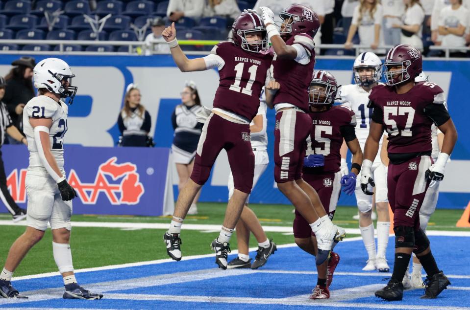 Harper Woods' Nate Rocheleau (11) and Dakota Guerrant celebrate a touchdown vs. Grand Rapids South Christian during the MHSAA Division 4 high school football state championship game at Ford Field in Detroit on Saturday, November 25, 2023.
