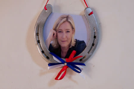 A horseshoe with a photograph of Marine Le Pen, French National Front (FN) political party leader and candidate for French 2017 presidential election, is seen on a wall at her local headquarters in Henin-Beaumont, France, April 6, 2017. REUTERS/Pascal Rossignol