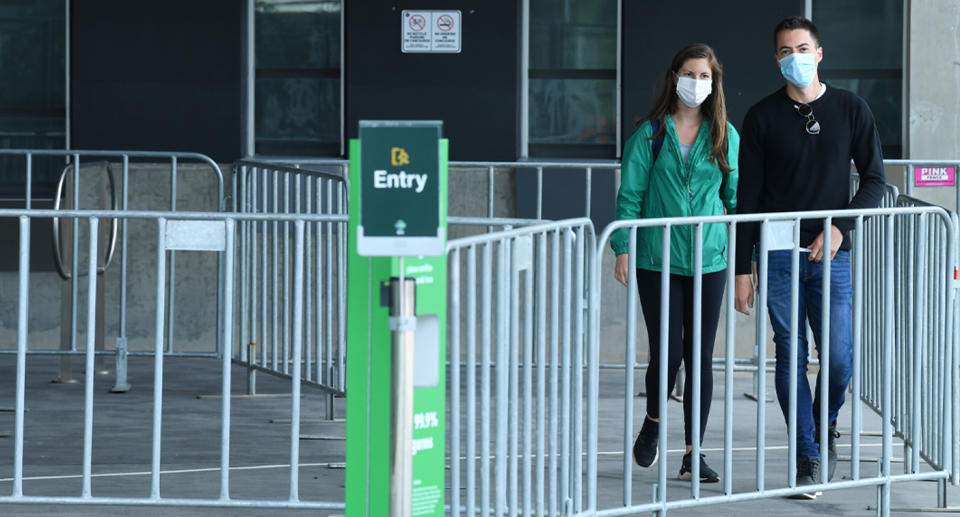 A couple leave the testing centre at the MCG.