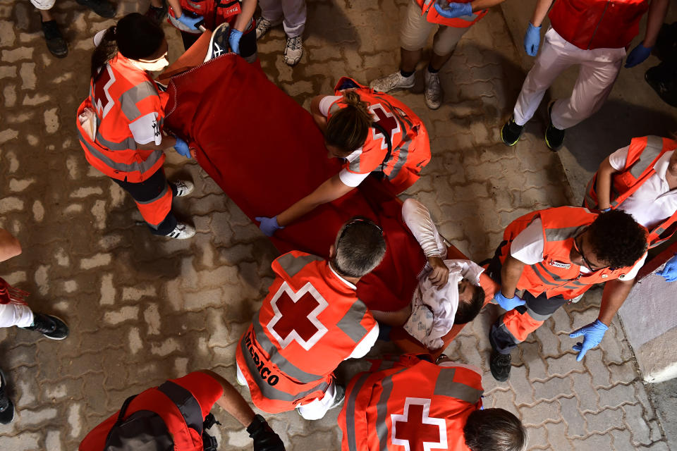 Medics help an injured runner on a stretcher during the running of the bulls at the San Fermin Festival in Pamplona, northern Spain, Tuesday, July 12, 2022. Revellers from around the world flock to Pamplona every year for nine days of uninterrupted partying in Pamplona's famed running of the bulls festival which was suspended for the past two years because of the coronavirus pandemic. (AP Photo/Alvaro Barrientos)