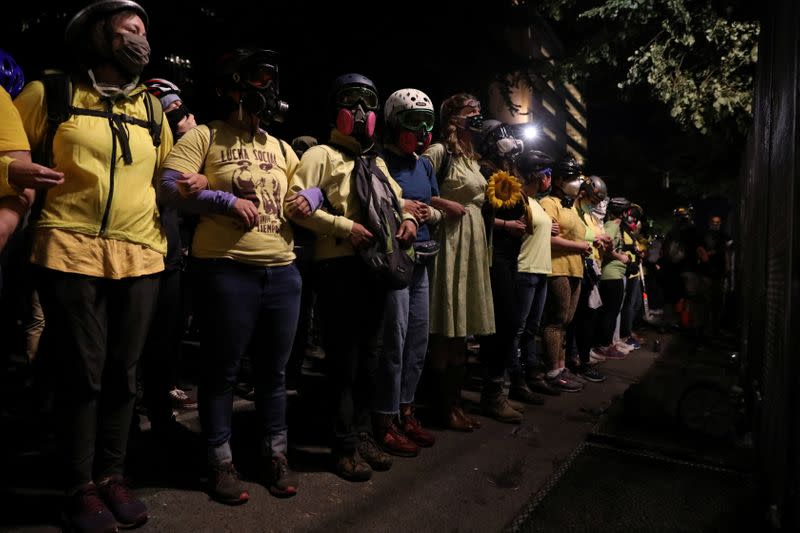 Federal law enforcement officers deployed under the Trump administration's new executive order face off with protesters