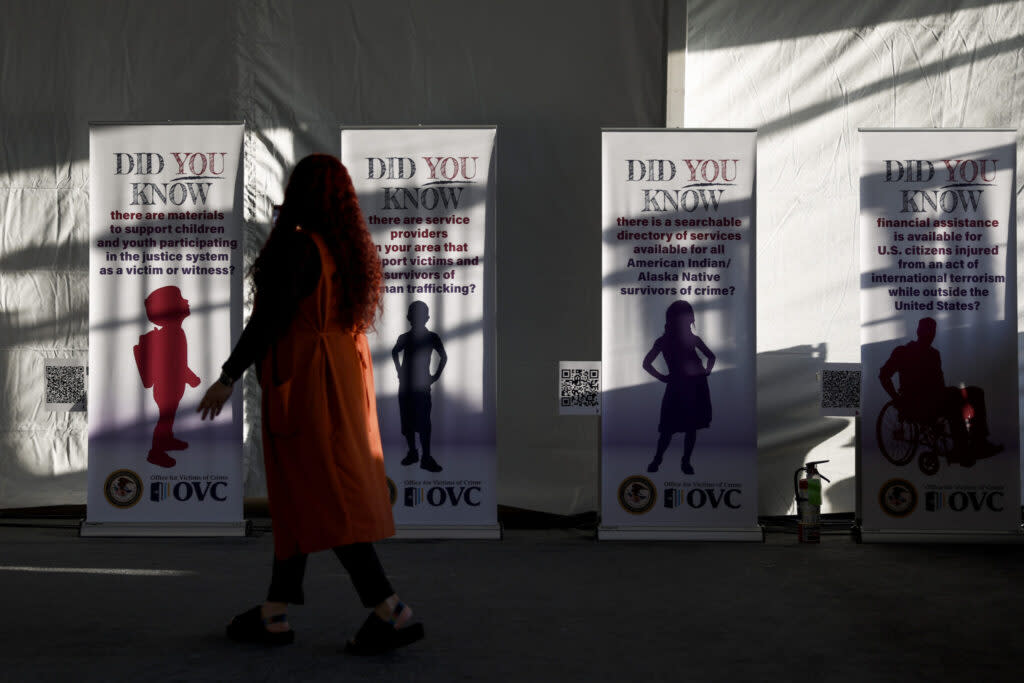 An attendee looks at a series of banners for National Crime Victims’ Rights Week