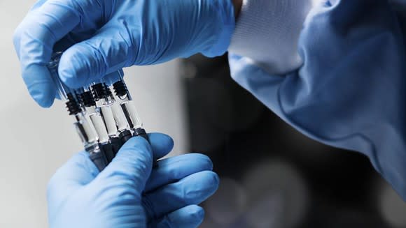 Pfizer scientist holding vials.