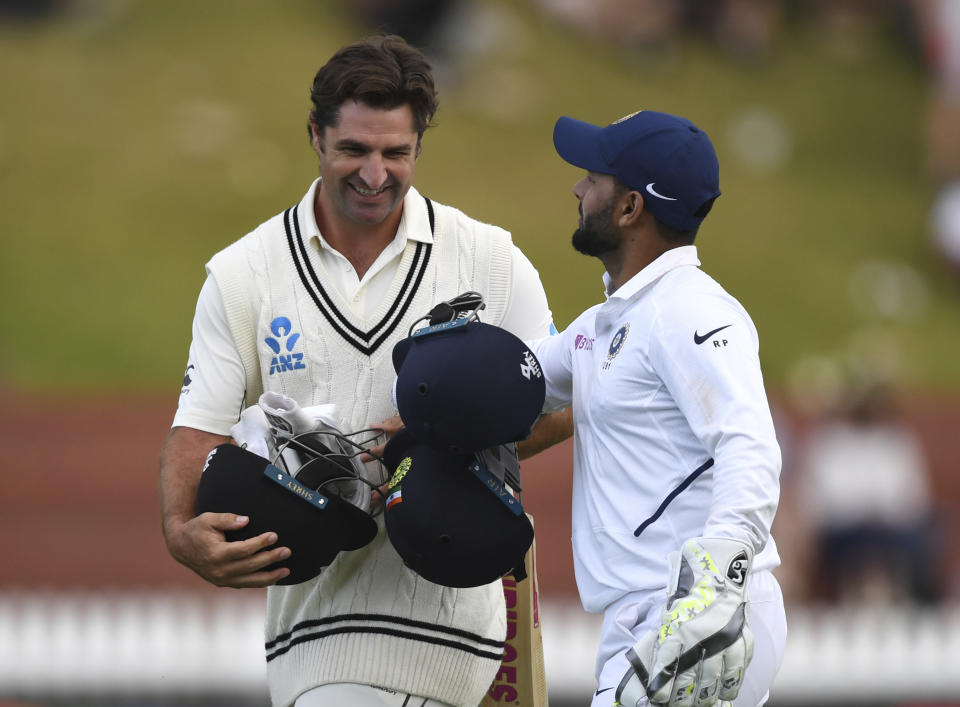 New Zealand's Colin de Grandhomme, left and India's Rishabh Pant share a joke as play ends because of bad light during the first cricket test between India and New Zealand at the Basin Reserve in Wellington, New Zealand, Saturday, Feb. 22, 2020. (AP Photo/Ross Setford)