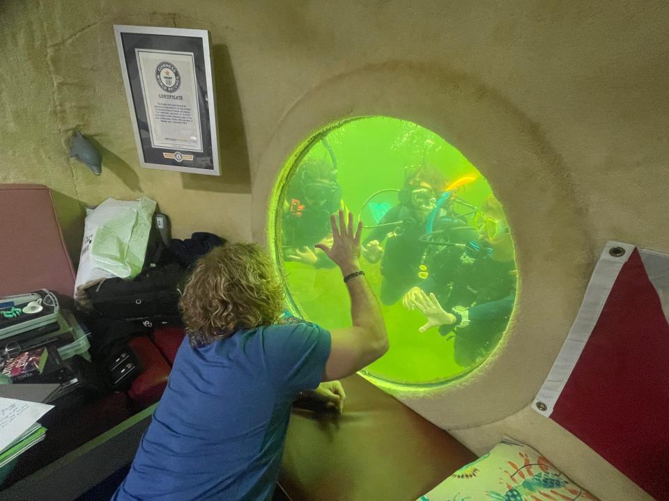 Scientist and retired US Navy saturation diver Joe Dituri greets divers from his 100 days underwater stay at Jules' Undersea Lodge.