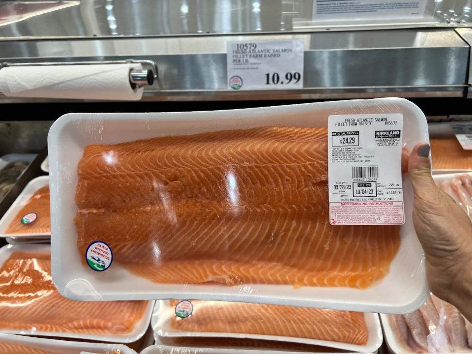 hand holding up a package of salmon at costco