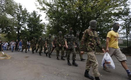 Volunteers walk before training at a base of the Ukrainian self-defence battalion "Azov" in the southern coastal town of Mariupol, September 7, 2014. REUTERS/Vasily Fedosenko