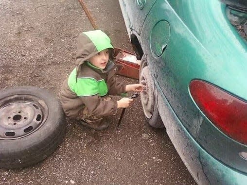 Dylan Spencer, who estimates he's about 6 years old in this 2011 picture, is working on the family's 1999 Ford Escort in his grandfather's driveway in Milan. Working with his grandfather helped Spencer grow comfortable with mechanics, he said.