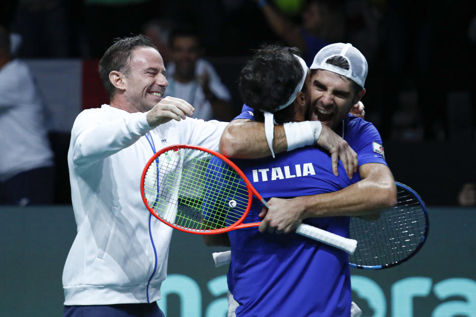 Filippo Volandri, capitán del equipo italiano, festeja mientras Simone Bolelli abraza a Fabio Fognini, en el festejo del triunfo sobre Estados Unidos en la Copa Davis, el jueves 24 de noviembre de 2022, en Málaga, España (AP Foto/Joan Monfort)