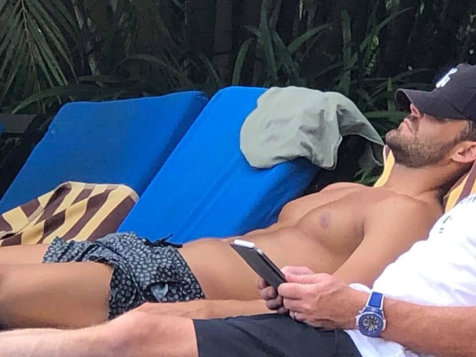 A photo of Carlin Sterritt shirtless laying by the pool in Fiji.