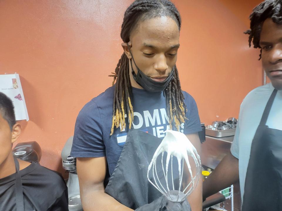Chris Underwood works with fellow students in the kitchen at Beautiful Rainbow Cafè.