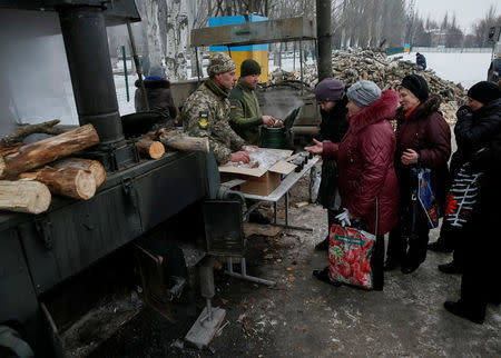 Local residents receive hot tea at an emergency center after shelling hit supply infrastructure in the government-held industrial town of Avdiyivka, Ukraine. The shelling eased this week, but Jan. 29-31 clashes near the Kiev-held front line town of Avdiyivka brought the festering conflict back into focus amid warnings of a looming humanitarian crisis in freezing winter temperatures. REUTERS/Gleb Garanich