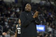 Georgetown head coach Patrick Ewing applauds while watching a replay on the videoboard during the first half of an NCAA college basketball game against Providence, Thursday, Jan. 20, 2022, in Providence, R.I. (AP Photo/Stew Milne)