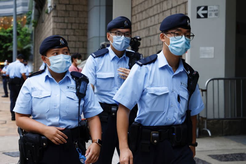 Police stand guards as a prison van arrive High Court on the first day of trial of Tong Ying-kit, the first person charged under a new national security law, in Hong Kong