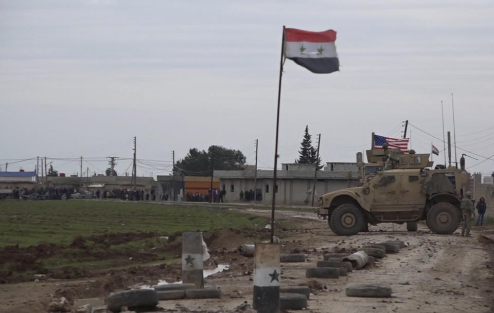 In this frame grab from video, an American military convoy is seen in the village of Khirbet Ammu, east of Qamishli city, Syria, Wednesday, Feb. 12, 2020. The Syrian official news agency SANA, said Wednesday, that locals had gathered at an army checkpoint, pelting the U.S. convoy with stones and taking down a U.S. flag flying on a vehicle when troops fired with live ammunition and smoke bombs. (AP Photo)