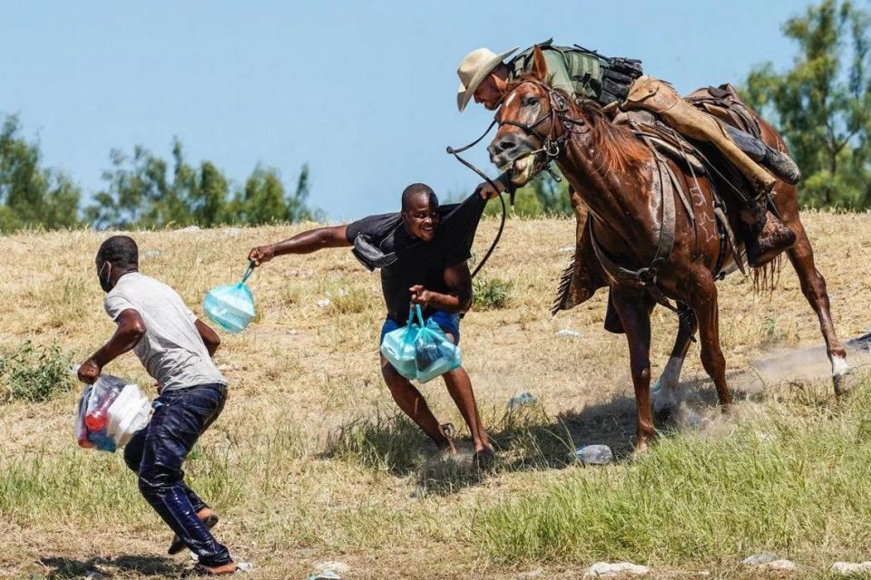 A border agent menaces a Haitian migrant at the Texas border, grabbing him and brandishing what appeared to be a whip.