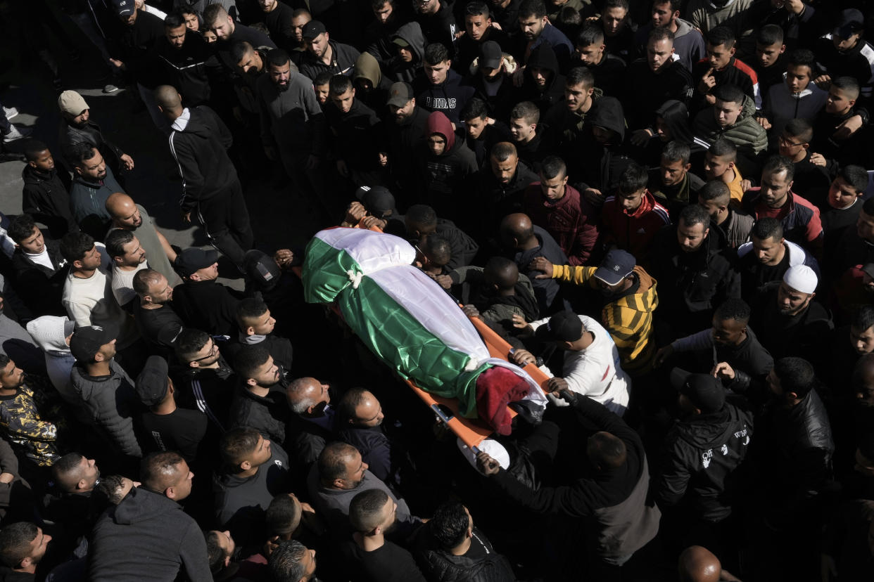 Mourners carry the body of a Palestinian woman, identified as Magda Obaid, 60, during her funeral in the West Bank city of Jenin, Thursday, Jan. 26, 2023. Palestinian health officials said Israeli forces killed at least nine Palestinians, including the Palestinian woman, and wounded several others during a raid in a flashpoint area of the occupied West Bank on Thursday, in one of the deadliest days in months of unrest. The Israeli military said it was conducting an operation to arrest a militant grouping linked to the Palestinian Islamic Jihad, which has a major foothold in the camp. A gun battle erupted, during which the military said it was targeting militants involved in planning and carrying out attacks on Israelis. (AP Photo/Majdi Mohammed)