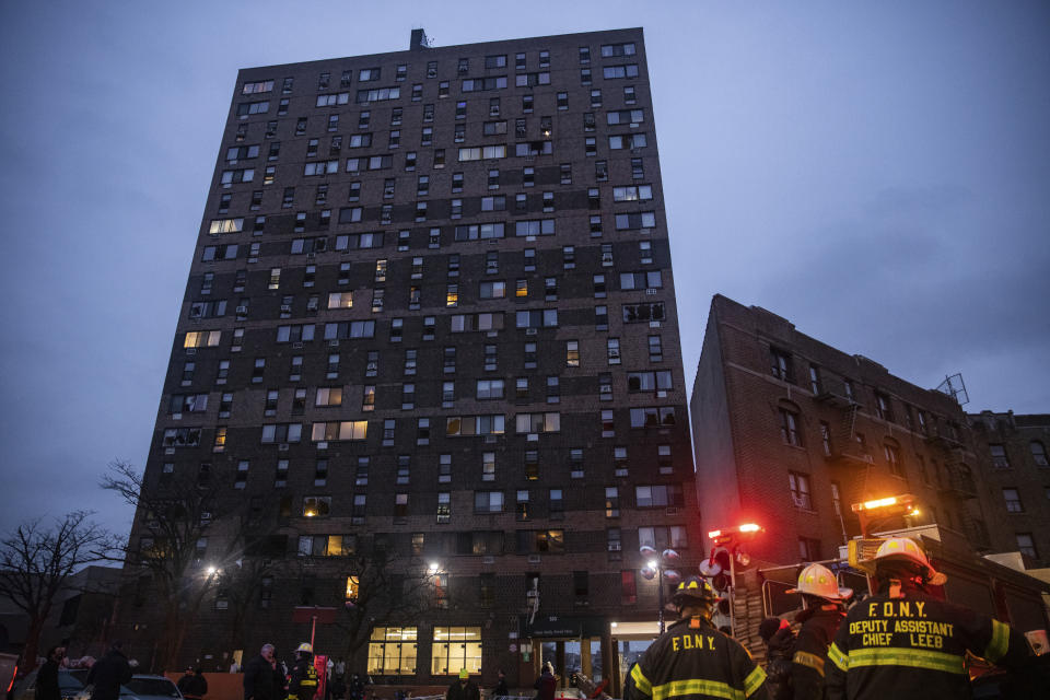 Emergency personnel work at the scene of a fatal fire at an apartment building in the Bronx on Sunday, Jan. 9, 2022, in New York. (AP Photo/Jeenah Moon)