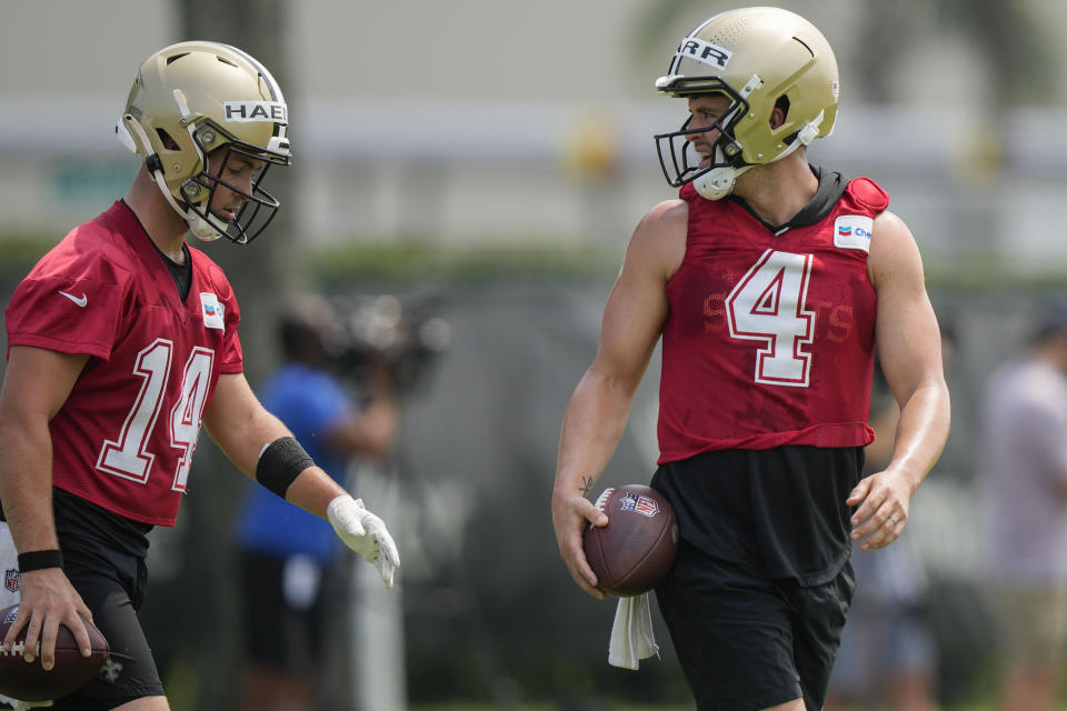 New Orleans Saints quarterbacks Derek Carr (4) and Josh Haener (14) walk through drills during an NFL football practice in Metairie, La., Tuesday, May 30, 2023. (AP Photo/Gerald Herbert)