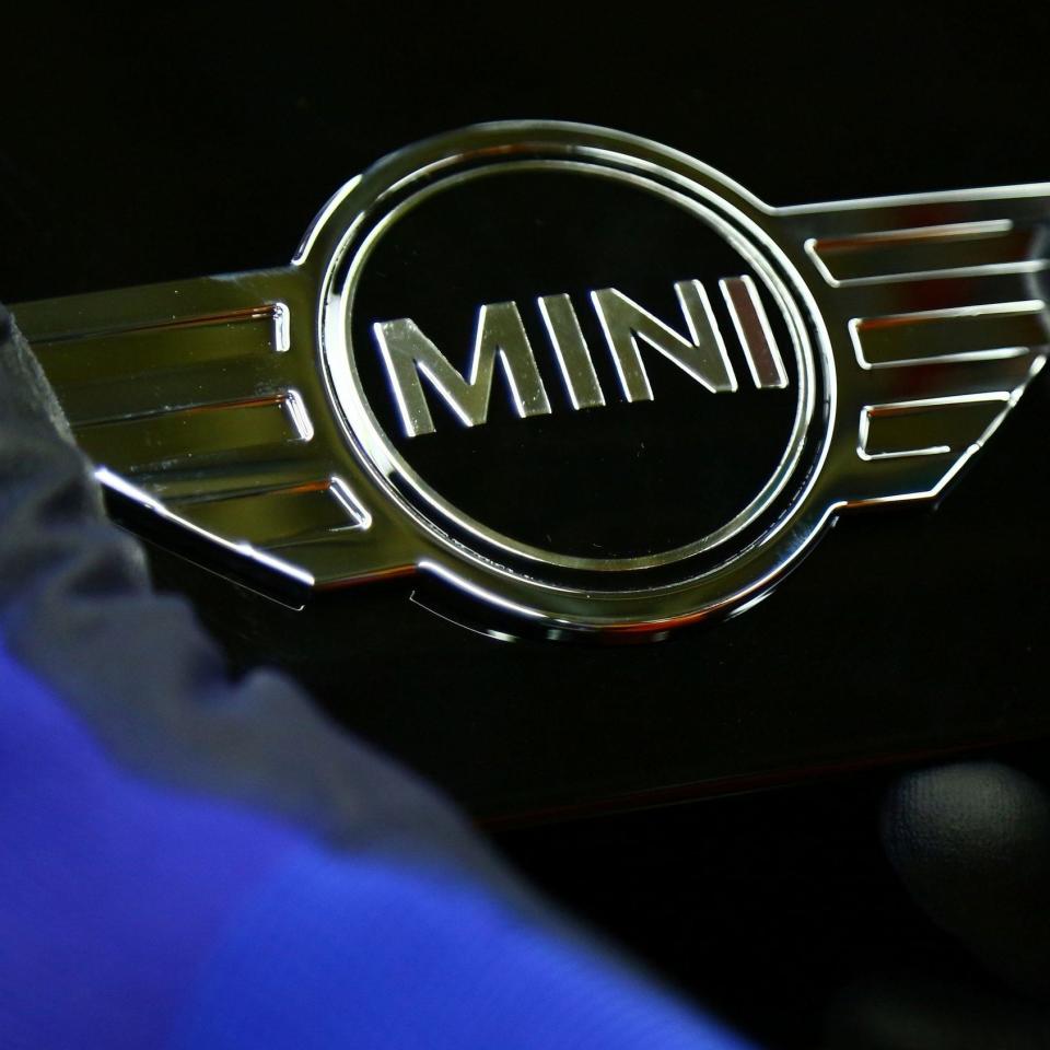 A Mini emblem is attached to one of the cars at the company's Oxford plant  - Credit: AFP