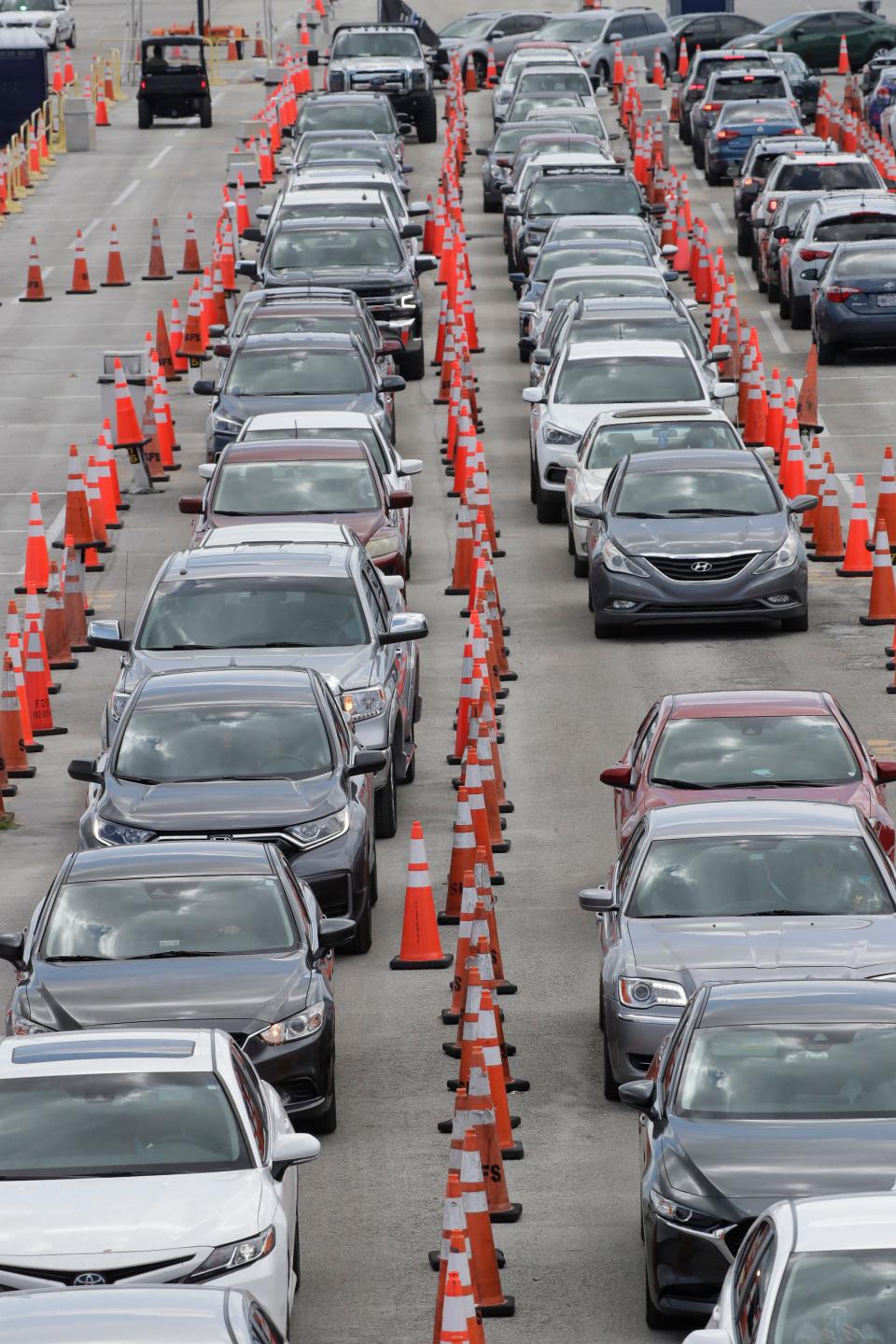 Cars wait in line at a drive-thru COVID-19 testing site July 8 in Miami Gardens, Fla. On July 13, Florida reported the largest single-day increase in positive coronavirus cases in any one state since the beginning of the pandemic.