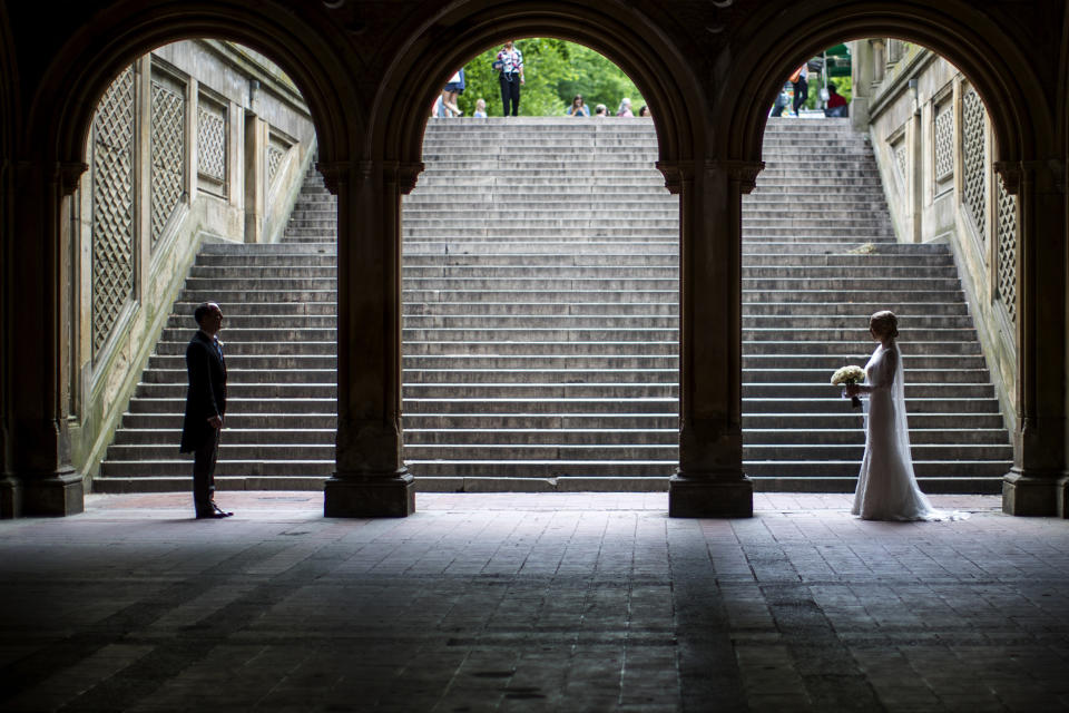 FILE - A bride and groom pose for wedding pictures at the Bethesda Terrace in New York's Central Park on May 23, 2017. (AP Photo/Mary Altaffer, File)