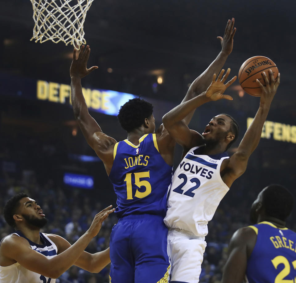Minnesota Timberwolves' Andrew Wiggins, right, shoots over Golden State Warriors' Damian Jones (15) during the first half of an NBA basketball game Friday, Nov. 2, 2018, in Oakland, Calif. (AP Photo/Ben Margot)