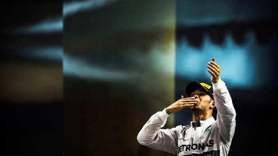 Lewis Hamilton acknowledging the fans from the podium after winning the 2014 Abu Dhabi Grand Prix and earning his first World Drivers' Championship title with Mercedes.