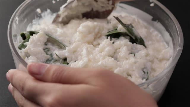 Stuffing pandan leaves into white rice and thick coconut milk