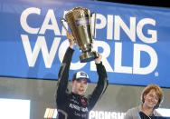 Ben Rhodes (99) lifts the cup after winning the NASCAR Camping World Truck Series Championship at Phoenix Raceway, Friday, Nov. 5, 2021, in Avondale, Ariz. (AP Photo/Darryl Webb)