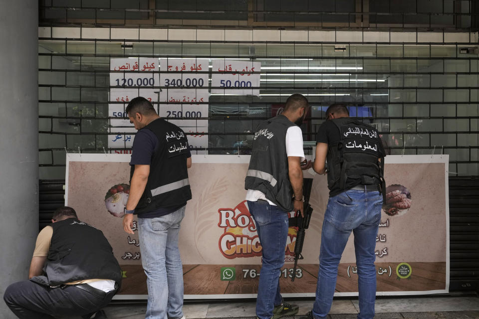 Lebanese General Security officers close a shop employing Syrians, as part of a crackdown on businesses employing unregistered Syrian workers in Beirut, Lebanon, Saturday, May 11, 2024. Hundreds of Syrians refugees left a remote northeastern Lebanese town back to Syria in a convoy Tuesday, amid a surge in anti-refugee sentiment in the small, crisis-hit country. The new push for repatriation comes as Lebanon's quarrelling ruling political parties have reached a rare consensus in recent years, all agreeing that Syrian refugees should be returned. (AP Photo/Hassan Ammar)