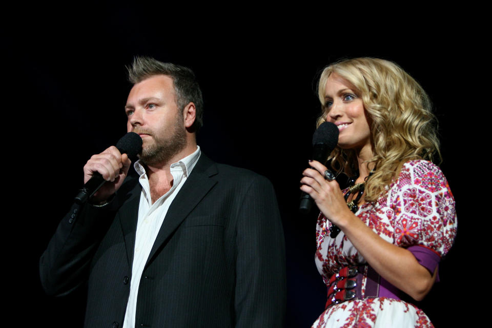 Closeup of Kyle and Jackie O holding up microphones