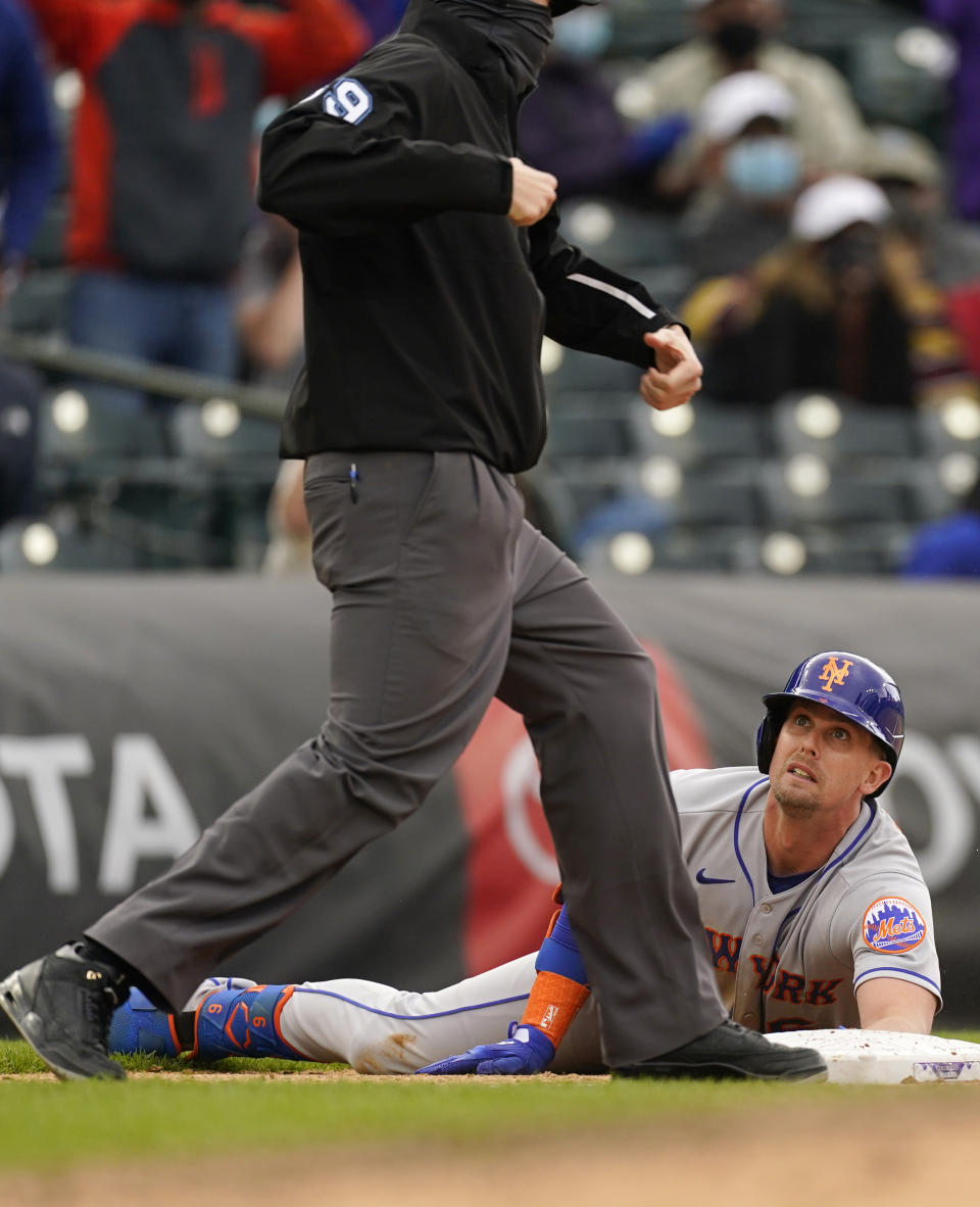 New York Mets' Jeff McNeil, right, reacts as he is called out by third base umpire Nic Lentz after McNeil tried to stretch a double into a triple in the ninth inning of a baseball game against the Colorado Rockies, Sunday, April 18, 2021, in Denver. (AP Photo/David Zalubowski)