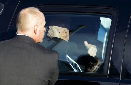 Republican presidential candidate Donald Trump gives a thumbs up to supporters waiting outside as he does a radio interview over the phone at a polling place for the presidential primary in Manchester, New Hampshire February 9, 2016. REUTERS/Rick Wilking